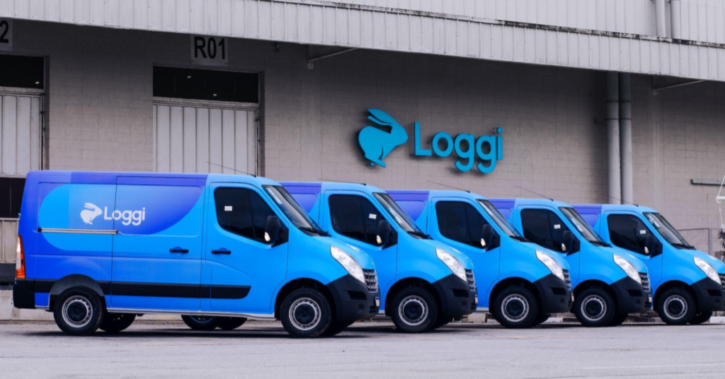 A imagens mostra diversas vans azuis na frente de um dos crossdockings da Loggi, em Cajamar. As frotas representam a combinação de tecnologia e logística para garantir melhores preços e melhores rotas.