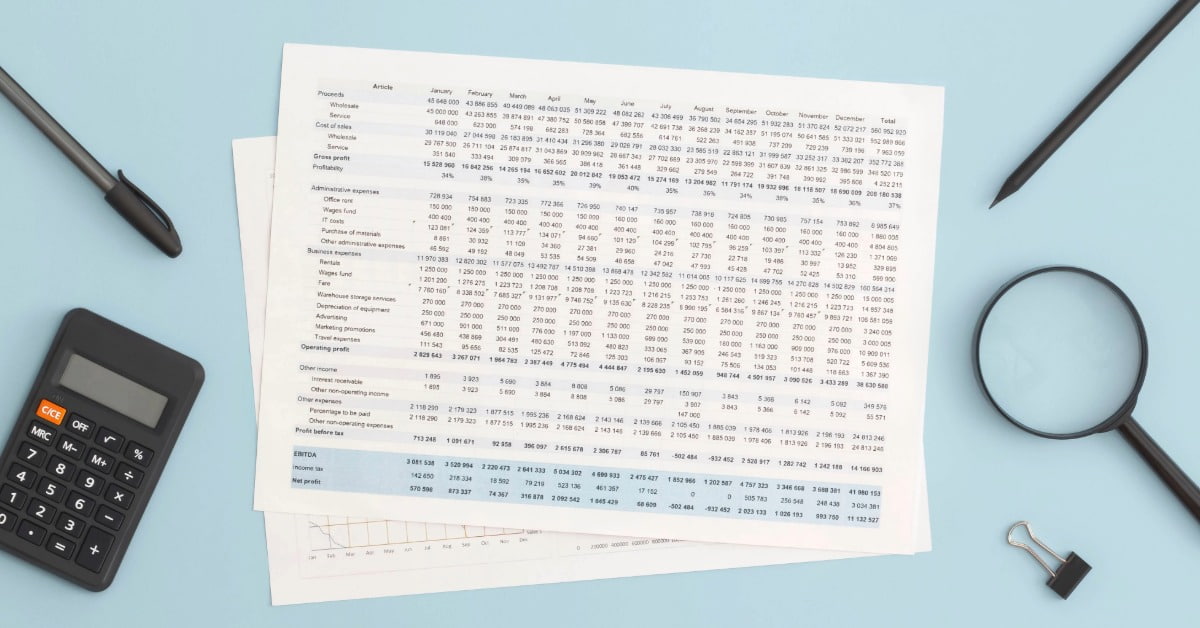 Planilha de controle de gastos impressa em uma mesa junto com calculadora e canetas