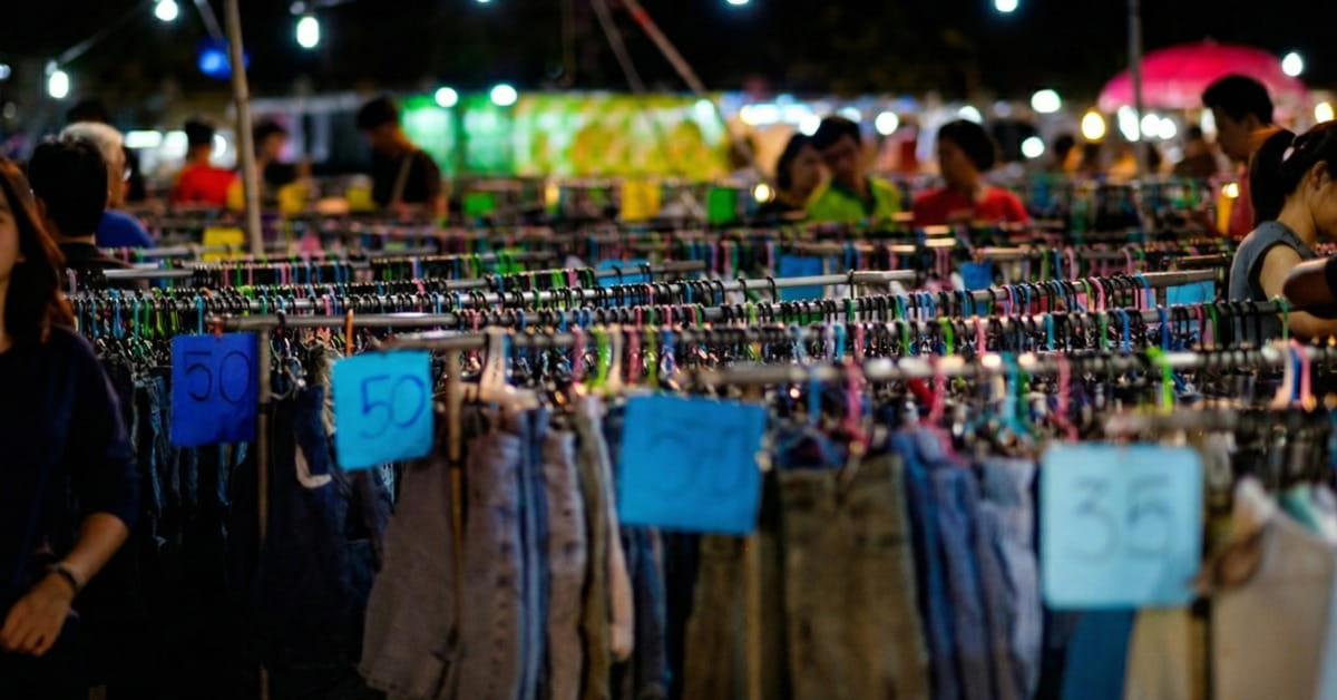 Araras de roupa e clientes de fundo na feira da madrugada sp