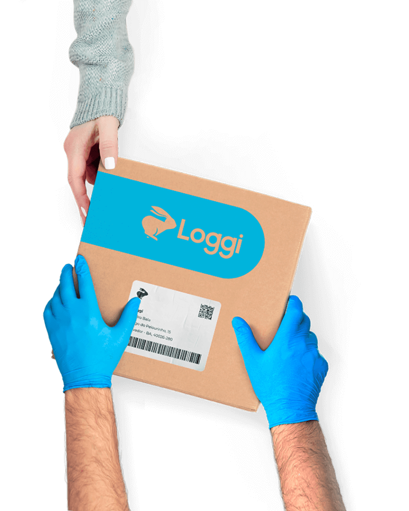 Mãos de um entregador parceiro, usando luvas azuis, entregando uma caixa parda da Loggi nas mãos de uma destinatária.
